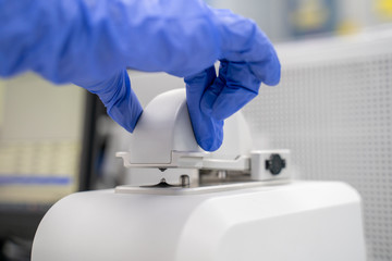 The researcher drops 2 micro-liters of the sample on pedestal to measures the RNA concentration and...