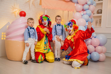 Obraz na płótnie Canvas Circus clowns at the birthday party. Little brothers and clowns. Party for children.