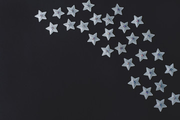 silver stars on a black background. holiday concept. creative layout, copy space