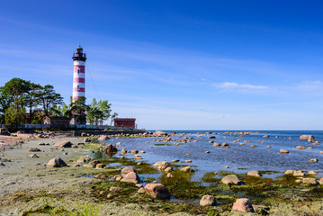 Shepelevsky lighthouse on the picturesque coast of the Gulf of Finland. Beautiful summer view of the Baltic sea coastline, Leningrad region, Russia