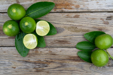 Fresh limes or green lemons on wood table background. Top view with copy space