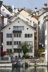 Fototapeta na wymiar Schipfe an der Limmat in der Altstadt von Zürich, Giebeldächer mit Schornsteinen, enge Gassen, Spiegelungen im Fluss, Hochformat