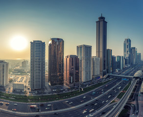 Skyscrapers and highways of a big modern city at sunset. View on downtown Dubai, United Arab Emirates.