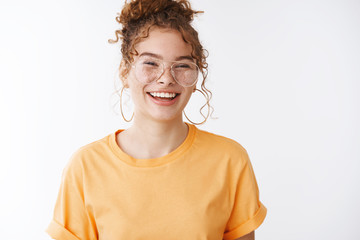 Carefree happy ginger girl wearing orange t-shirt glasses laughing out loud hilarious humor joke...