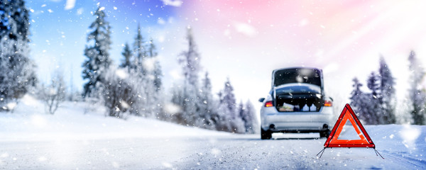 Car triangle on winter road. Problem with vehicle on snowy road. Broken cars concept. Panorama of snowy winter road.