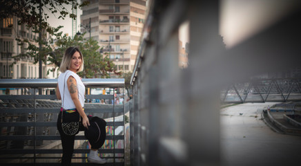 Fototapeta na wymiar young woman on a railing smile, buildings background ,lifestyle