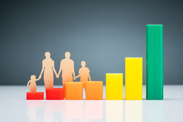 Family Cutout Paper Behind Chart On Desk