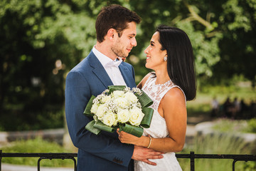 A happy couple on their wedding day. A French European groom and a Latin American (Peruvian) bride, looking at each other and smiling.