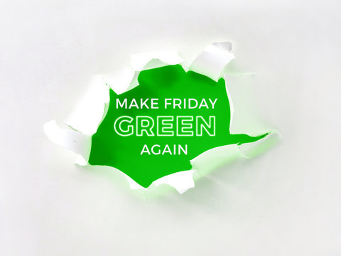 Teared paper hole in white paper over bright and vibrant green color. Motivating slogan "Make Friday green again" urgung consumers to ignore Black Friday sale in torn paper frame.
