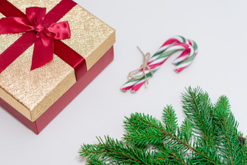 Christmas gifts box, branches and candy canes against a white background