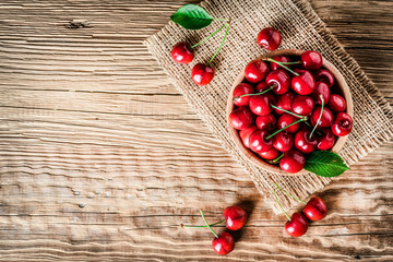 Fototapeta na wymiar Fresh ripe cherry on wooden background. Top view of cherries in bowl .