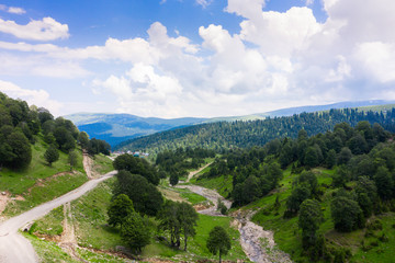 Obraz premium Beautiful nature with river valley and road and traditional wooden houses on the road through the Goderdzi Pass in Georgia.