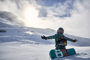 Happy Snowboarder with snowboard, winter at the mountain
