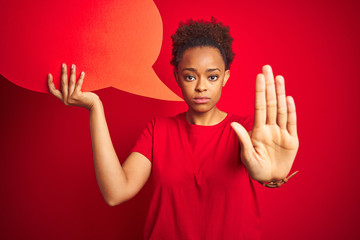 Young african american woman holding speech bubble over red isolated background with open hand...