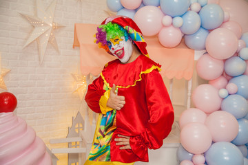 Cheerful circus clown shows emotions of the holiday