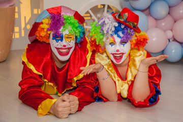 Funny clowns from the circus. Clown boy and clown girl show emotions