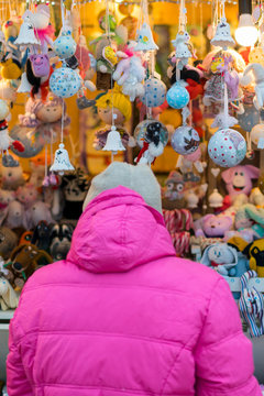 woman chooses souvenirs at the Christmas market. back view. vertical photo