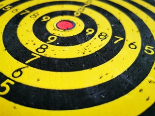 Target for throwing Darts. Black and yellow concentric circles with digital markings and dart marks