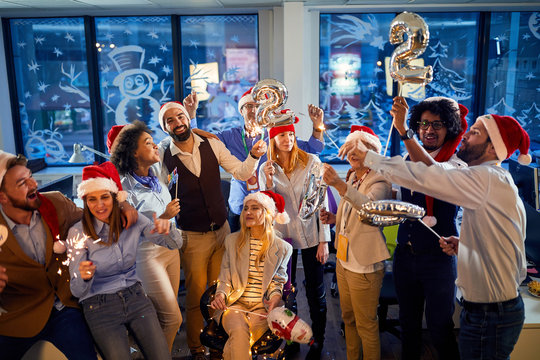 happy business people in santa hats celebrating holiday at office.