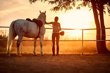 Foto op Canvas Female horse rider in a company of her horse © luckybusiness