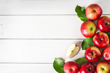 Fresh red apples on white background top view. Green apple leaves and fruits copy space.