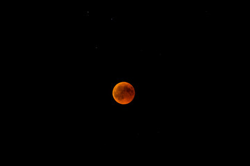 Reddish colored moon, also called blood moon during an lunar eclipse. It occurs when the Moon passes directly behind Earth and into its shadow. This occurs when the Sun, Earth, and Moon are aligned