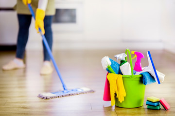 Bucket with cleaning items with modern kitchen and  background. Washing brush and spray set with copy space. - Powered by Adobe