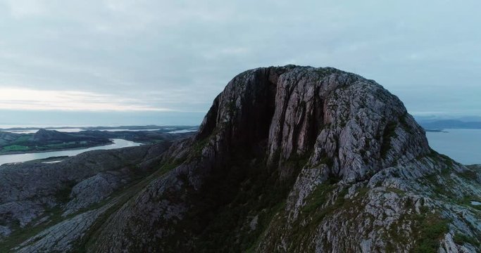 4K wide drone shot with parallax motion of the natural glacial made tunnel through the popular mountain and tourist attraction Torghatten and a panoramic ocean view, in Br&oslash;nn&oslash;ysund Helgeland Norway.