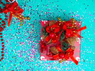 Red gift box on blue bacground with conetti, Flat lay background. Festive concept. Selective focus