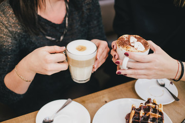 Two young women drinking coffee together in a cafe