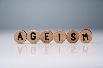 Ageism Text On Round Blocks Over White Desk