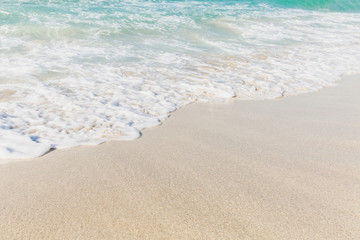 Turquoise sea wave surface on a sandy beach. Background. Space for text.
