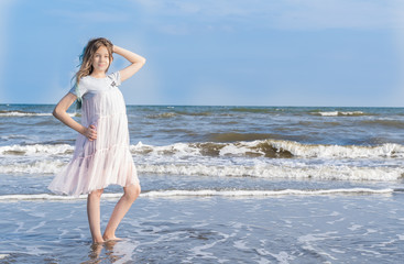 Fototapeta na wymiar Adorable girl dancing by the sea