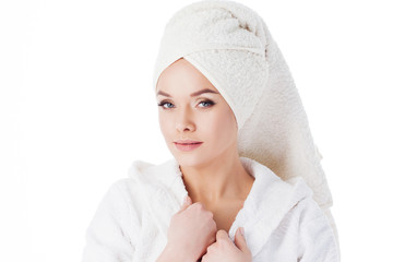 Obraz premium Beauty treatments after the bath. Portrait of a young beautiful woman in a Terry robe and with a towel on her head.