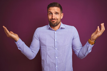 Young business man wearing elegant shirt over purple isolated background clueless and confused...