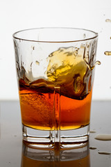 splashing whiskey in a glass on the background