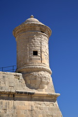 tower of medieval wall in Valetta city, malta, against blue clear sky