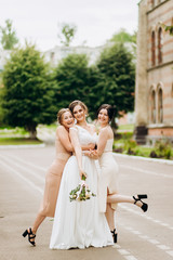 Luxury girls in gorgeous dresses posing on building background