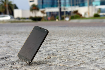 Smartphone falling and crashing on pavement