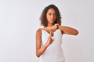 Young brazilian woman wearing casual t-shirt standing over isolated white background Doing time out gesture with hands, frustrated and serious face