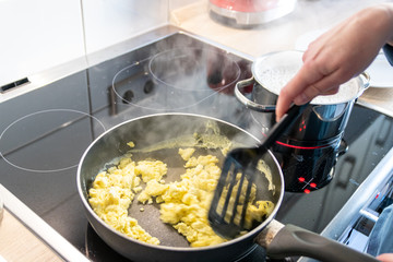 Frau kocht zum Mittagessen Omelette und Rührei für die Familie als leckeres und gesundes Essen...