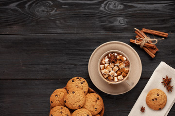 Christmas drink like cocoa with marshmallows and cookies on black background as a christmas card with copyspace for text