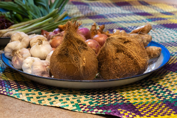 Obraz na płótnie Canvas Composition of assorted raw food, coconut, onion, ginger, garlic and lemongrass on traditional malay mats