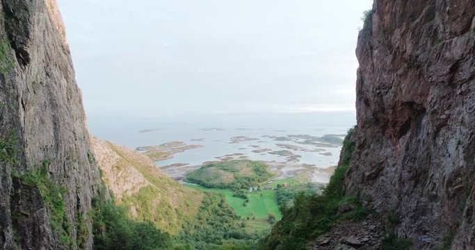 4K wide drone shot with backward motion of the scenic ocean view from a natural glacial made tunnel through the popular mountain and tourist attraction Torghatten, in Br&oslash;nn&oslash;ysund Helgeland Norway.