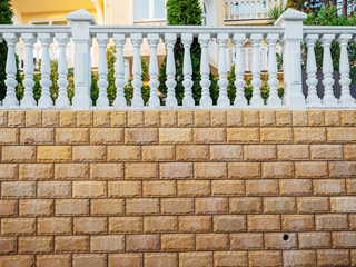 Beautiful fence with decorative stone and white balusters