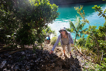 Tourists climb to the top of the cliff of remote archipelago Pulau Wayag, Raja Ampat, Indonesia