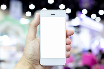 Close-up of a young woman using a cell phone on a blank white screen in the middle of a mall, Space for text