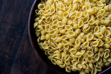 Italian Raw Pasta Shells Conchiglie / Conchiglioni in Wooden Bowl.