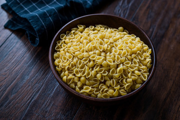 Italian Raw Pasta Shells Conchiglie / Conchiglioni in Wooden Bowl.