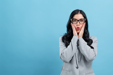 Surprised young woman posing on a blue background